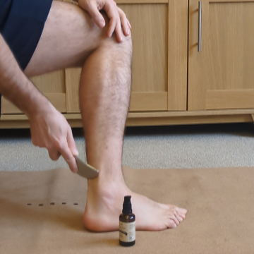 man using the Myoscraper on his Achilles